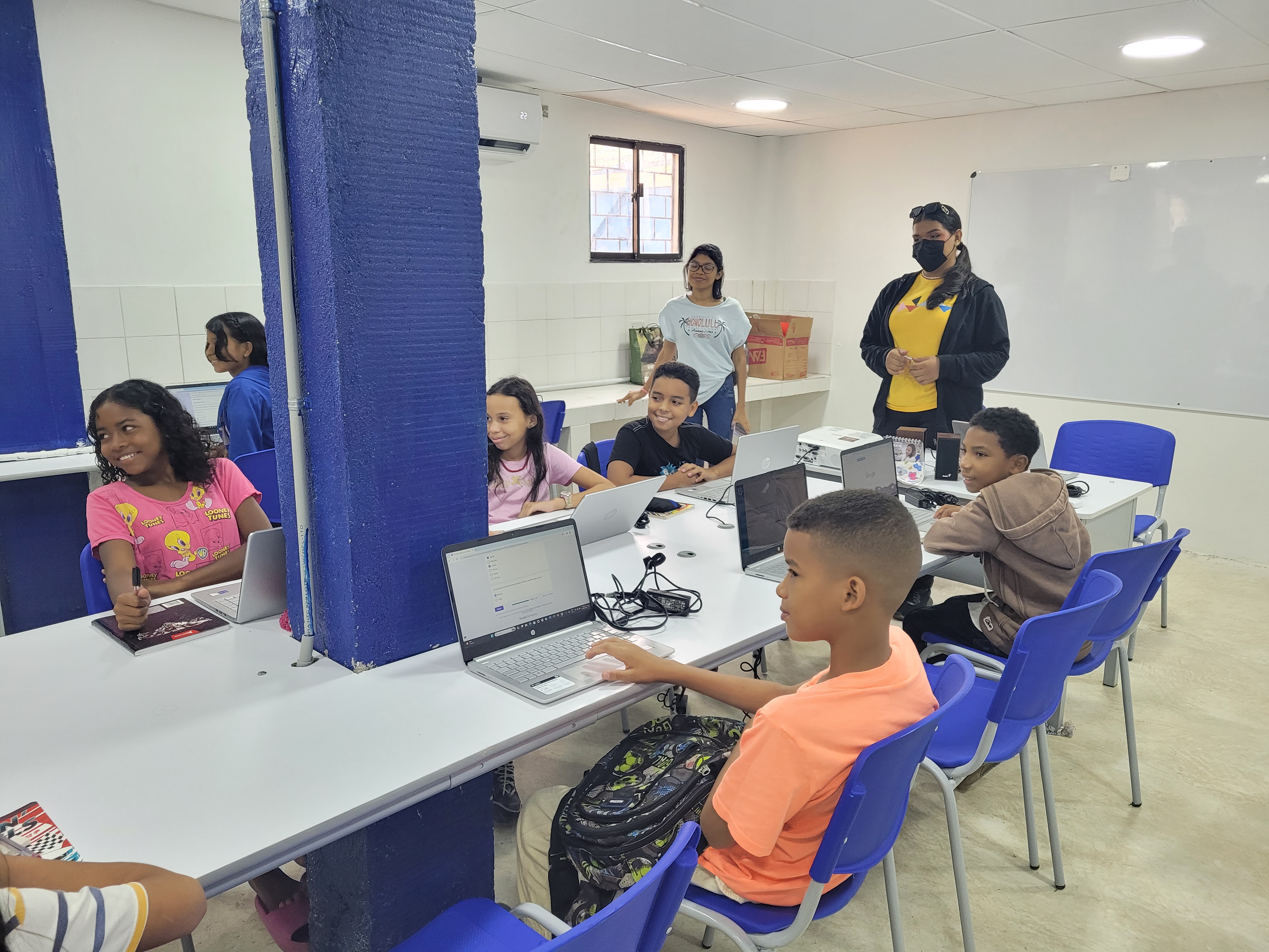 group d'enfants et professeur dans un atelier informatique